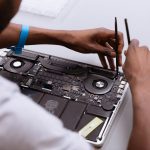 a man working on a laptop with a pair of scissors